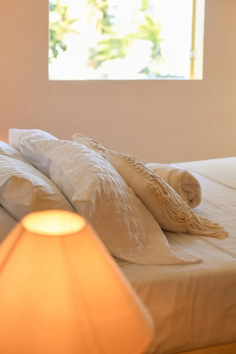 Cama arrumada com abajur aceso