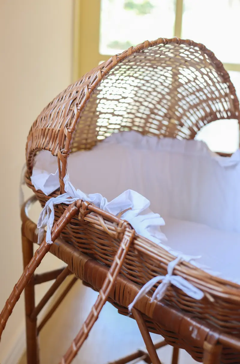 Berço de palha com enxoval branco