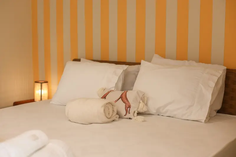 Cama da suíte de apoio com toalhas enroladas
